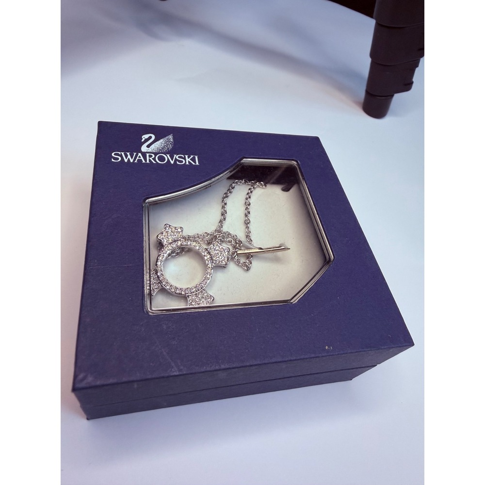 Swarovski necklace features a silver-tone chain with an open circle pendant